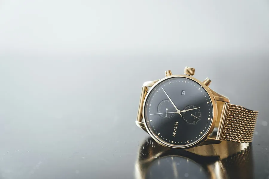 A gold-cased YELM chronograph on a Milanese mesh bracelet.